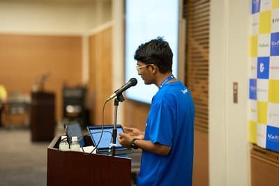 Abhik Sarkar speaking at a podium during the PyCon Japan Cython talk